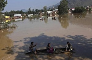 Kashmiri people row boats to cross the flooded areas as they move toward higher ground in Srinagar