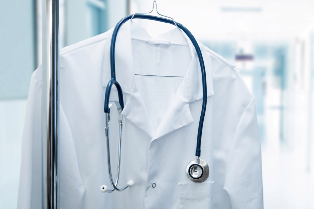 job vacancy - white doctor coat on hanger in hospital hallway